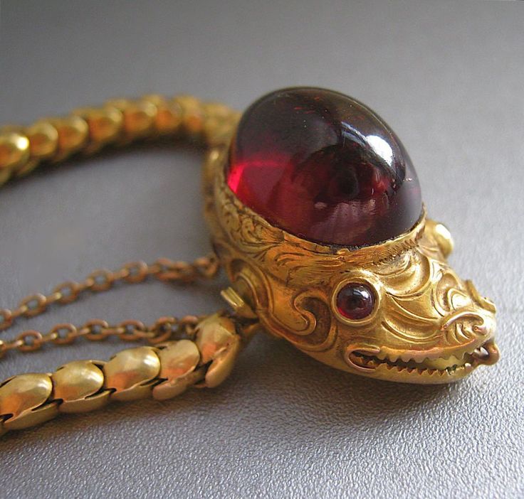 Serpent bracelet, circa 1845, garnet cabochon and gold chain.