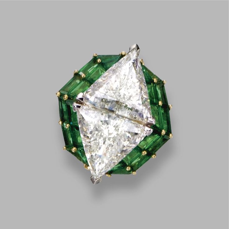 DIAMOND AND EMERALD RING, OSCAR HEYMAN & BROTHERS, 1993 Set with 2 triangular-sh...