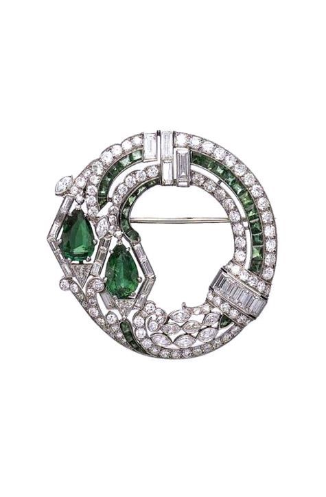 N ART DECO EMERALD AND DIAMOND BROOCH. Set with two pear-shaped emeralds, within...