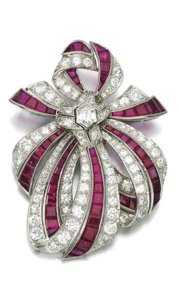 Ruby and diamond brooch, 1950s Of ribbon bow design, set with calibré-cut rubie...