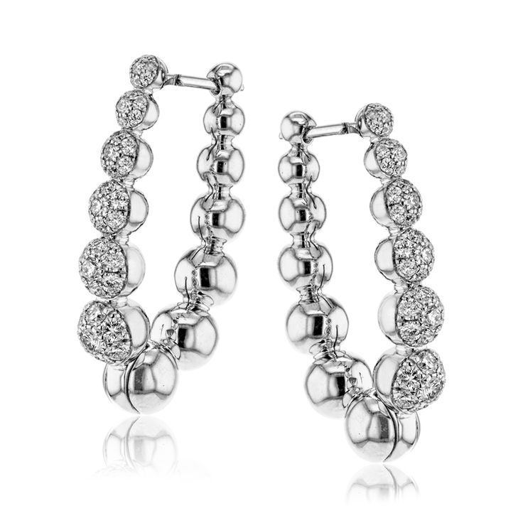 The white gold droplets of these gorgeous earrings glitter with 1.00 ctw of whit...
