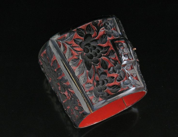 Cinnabar and black lacquer bracelet: the black lacquer is carved away to expose ...