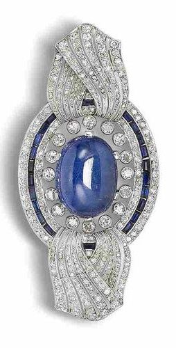 A sapphire, synthetic sapphire and diamond brooch, circa 1915. The oval cabochon...