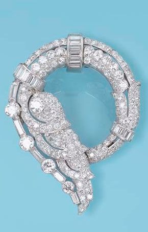 *AN ART DECO DIAMOND BROOCH Designed as a pavé-set diamond stylised wave with c...