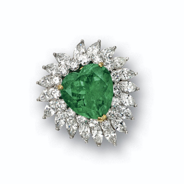 EMERALD AND DIAMOND BROOCH. The heart-shaped emerald weighing 19.65 carats, with...