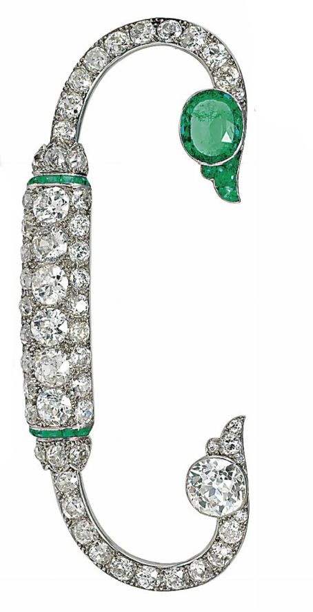 AN EMERALD AND DIAMOND BROOCH, BY CARTIER  Of fibula design, the pavé-set old-c...