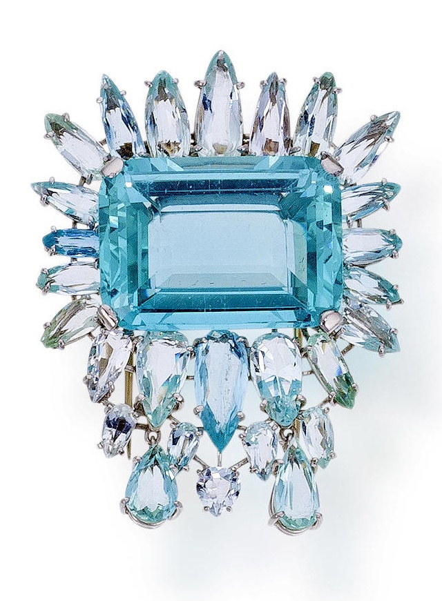 An aquamarine brooch  centering a cut-cornered rectangular-cut aquamarine, surro...