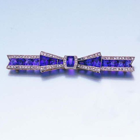 An early 20th century amethyst and diamond bow brooch, circa 1915  The tied ribb...