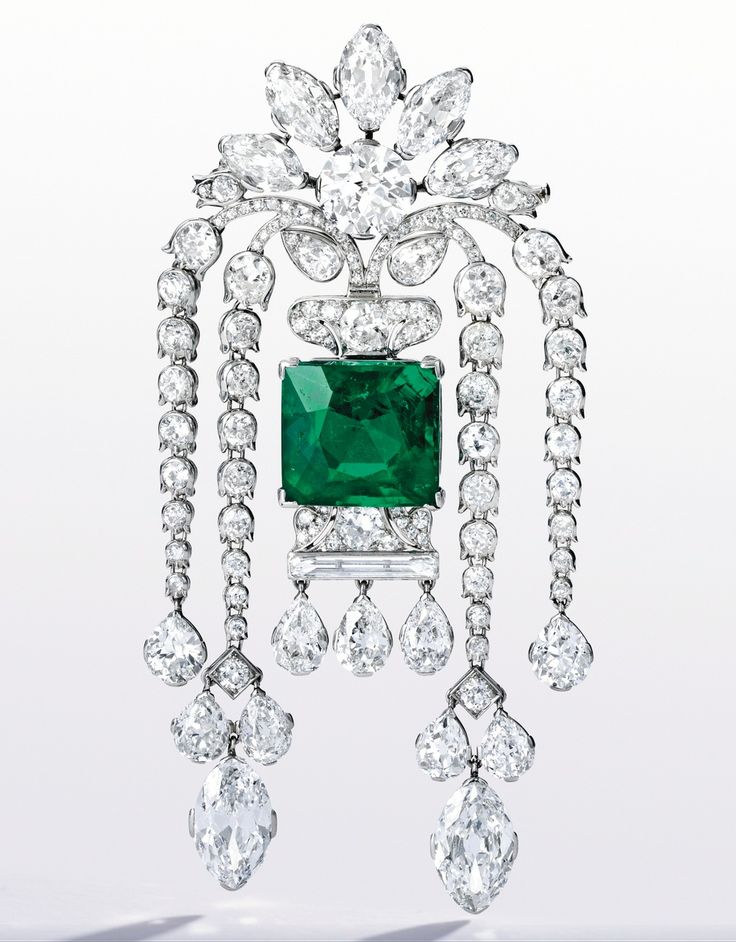 PLATINUM, EMERALD AND DIAMOND BROOCH – An emerald and diamond brooch centered ...