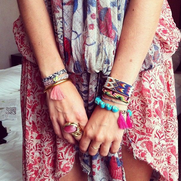 Layers of brightly coloured woven friendship bracelets and statement rings | rel...