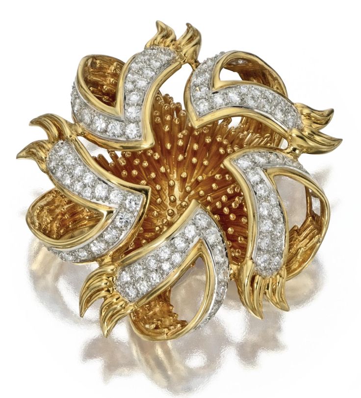 18 KARAT GOLD AND DIAMOND BROOCH, TIFFANY & CO.  The stylized sea urchin with do...