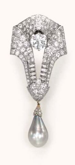 A DIAMOND AND PEARL BROOCH, BY CARTIER  Designed as a pavé-set diamond scroll, ...