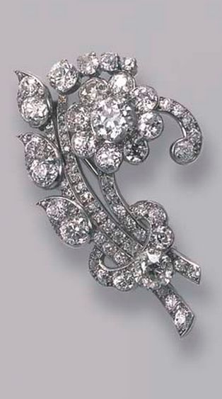 A DIAMOND FLORAL SPRAY BROOCH, BY CARTIER Designed as an old-cut diamond floral ...