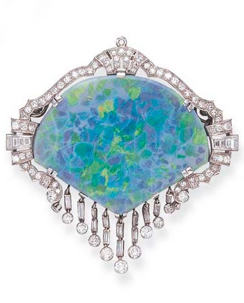 AN OPAL AND DIAMOND BROOCH  Set with a shield-shaped opal, within a scrolling si...