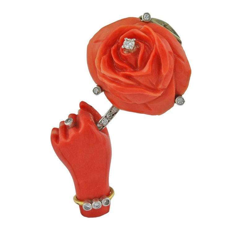 // Cartier Paris pin of a carved coral hand and rose (1940)