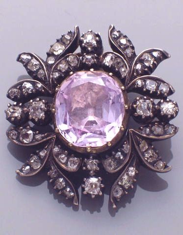 A Georgian pink topaz, diamond and silver-topped gold brooch centering an oval-s...