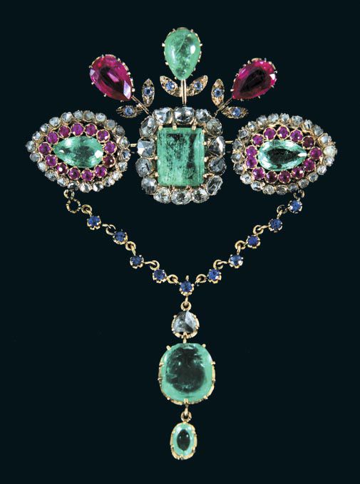 Gold set with three emeralds, one rectangular on a bed of rose-cut diamonds, the...
