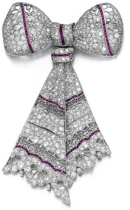 RUBY AND DIAMOND BROOCH, CIRCA 1910. Designed as an articulated ribbon bow, pier...