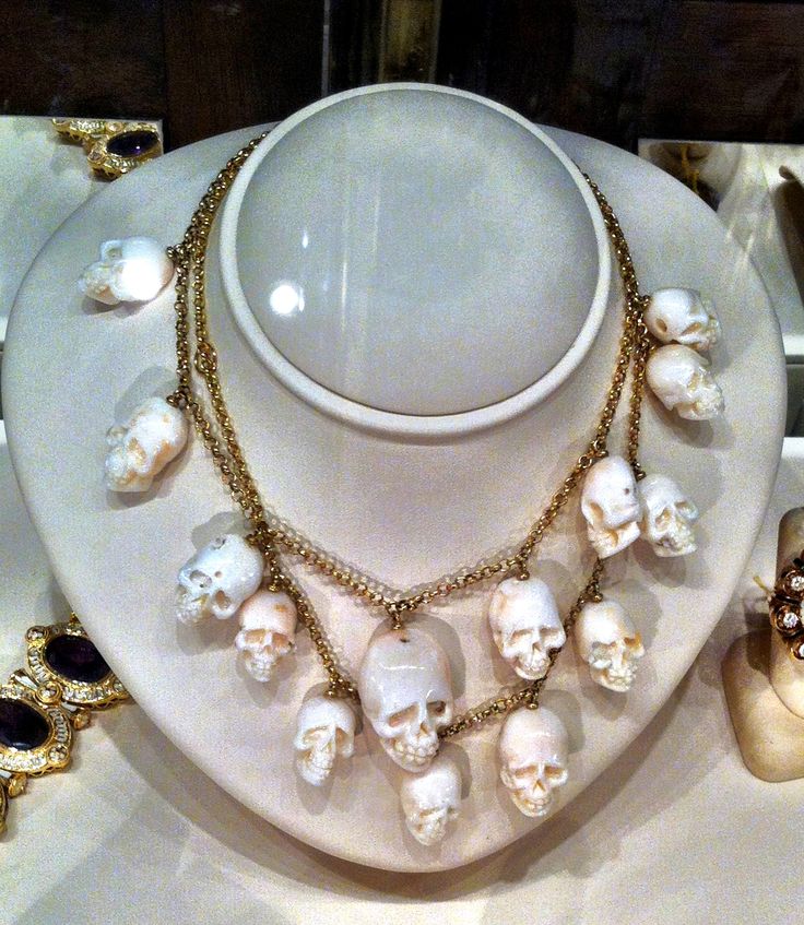 Carved white coral skulls and gold necklace.